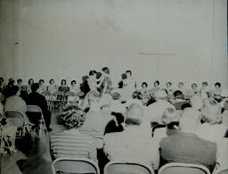 (133-01) Rose Ceremony 1960: Rose Is Pinned On (Two Women Wearing Patterned Dresses)