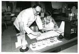 Professor and Student Working on Lab Experiment (Part of the NMU Historic Photographs Collection)