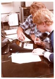 Two Students Working with Electronic Machine (Part of the NMU Historic Photographs Collection)