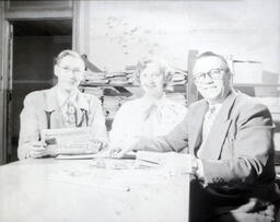 Faculty: Two Men, One Woman Seated Posed for Photo