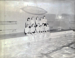 NMC Swimming Team 1961: Ten Men in Swim Trunks on Edge of Pool