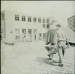 Former Campus Scenes: Construction Worker Pushing Wheelbarrow