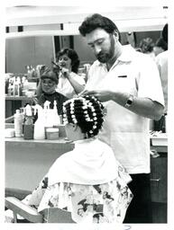 Man in Salon Putting Curlers into Woman’s Hair (Part of the NMU Historic Photographs Collection)