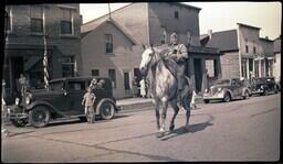 (008-042) Man in Military Uniform Riding Horse in Ontonagon Fourth of July Parade