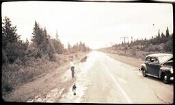 (024-005) Men and Car with Hood Raised on M-64 after Flood