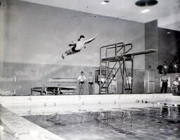 (153-11) Swimming Team: Diver Mid-Dive Off Springboard