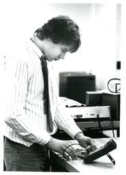 Student Working with Small Electronic Device (Part of the NMU Historic Photographs Collection)