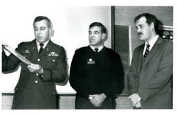 Schweppe, McCluskey, and Unknown Man Looking at Award (Part of the NMU Historic Photographs Collection)