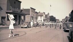 (008-001) Marching Band Performing in Ontonagon Fourth of July Parade in front of City Shoe Shop