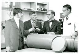 Robert Wagner, John X. Jamrich, and Two Unknown Men Pose in Physics Lab (Part of the NMU Historic Photographs Collection)