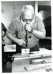 Man Using Hand Drill on Item in Clamp (Part of the NMU Historic Photographs Collection)