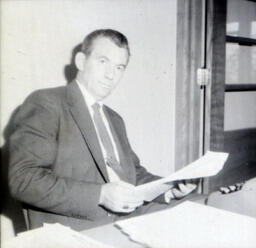 Dr. Stanley Moody: Dr. Stanley Moody Seated Holding Papers