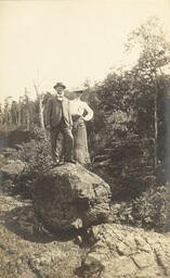 Man and woman standing on a boulder