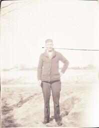 (132-010) Man Standing in Field with Cigarette