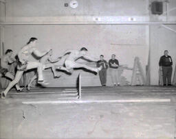 Track--NMC vs. Marquette Feb. 11, 1961: Men Jumping Hurdles at Track Meet