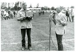 Man Speaking into Microphone while Another Man Holds a Trophy (Part of the NMU Historic Photographs Collection)