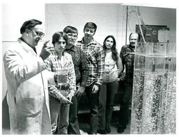 Students and Professor Gathered around Large Tubes of Liquids (Part of the NMU Historic Photographs Collection)