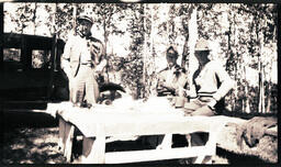 Three Men Around a Table