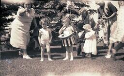 (008-025) Women Trying to Make Costumed Children Pose for Picture