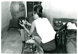 Woman Places Headphones onto Child (Part of the NMU Historic Photographs Collection)