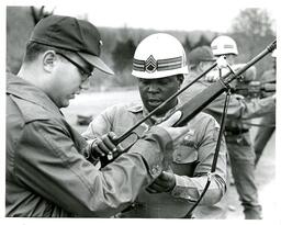 Man Demonstrating Something on Gun to Another Man (Part of the NMU Historic Photographs Collection)