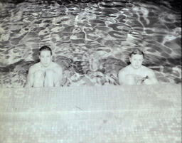 NMC Swimming Team 1961: Two Men in the Pool Looking at the Camera from the Pool's Edge