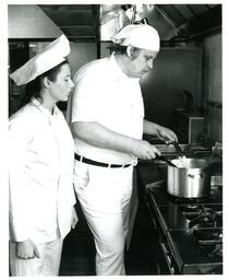 Woman Watching Man Cooking Something in Stock Pot (Part of the NMU Historic Photographs Collection)