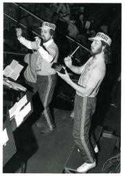 Band Director and Cowbell Player on Bleachers (Part of the NMU Historic Photographs Collection)