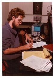 Student Taking Notes next to Electronic Machine (Part of the NMU Historic Photographs Collection)