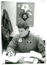 Bill Horacek Looking at Papers on Desk (Part of the NMU Historic Photographs Collection)