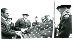 Men in Military Uniforms and John X. Jamrich Holding an American Flag (Part of the NMU Historic Photographs Collection)