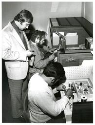 Professor Watching Students Work on Electronics in Cubicles (Part of the NMU Historic Photographs Collection)