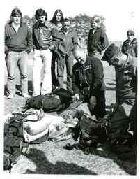 Two Men in Military Uniforms Inspecting Parachute Packs while Spectators Watch (Part of the NMU Historic Photographs Collection)