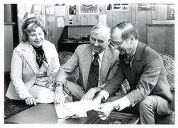 John X. Jamrich and Two Unknown People Smiling at Papers (Part of the NMU Historic Photographs Collection)