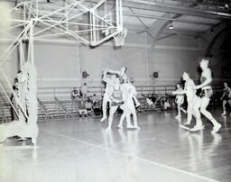 NMC Alumni Basketball 1960-61: Another Photo of Men Playing Basketball by Net