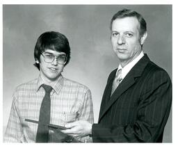 Student Receives Plaque from Unknown Man (Part of the NMU Historic Photographs Collection)