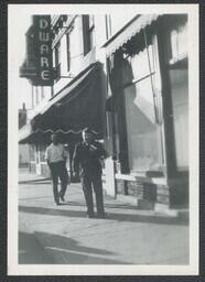 (015-006) Two Men in Front of Hardware Store