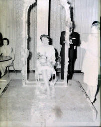 (591) Michigan Intercollegiate Snow Queen--All-Events Weekend--Stephanie Cizek; Jackson Community College 1961: Girl with Flowers Sitting Under Flowery Arch