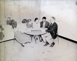 (588-01) NMC International Club and Advisor Charles Mighell: Five People Sitting at Table