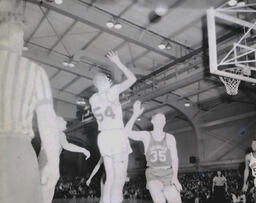 NMC Basketball--Aquinas Basketball 1960-61: Two Basketball Players by Net During Game