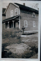 Two Kids Standing Outside of House