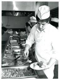 Kitchen Staff Putting Food on Plate (Part of the NMU Historic Photographs Collection)