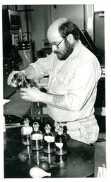 Man Pouring Liquid from One Container into Another (Part of the NMU Historic Photographs Collection)