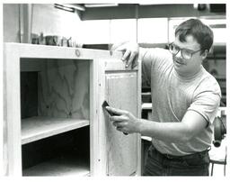 Man Using Chisel on Cabinet (Part of the NMU Historic Photographs Collection)